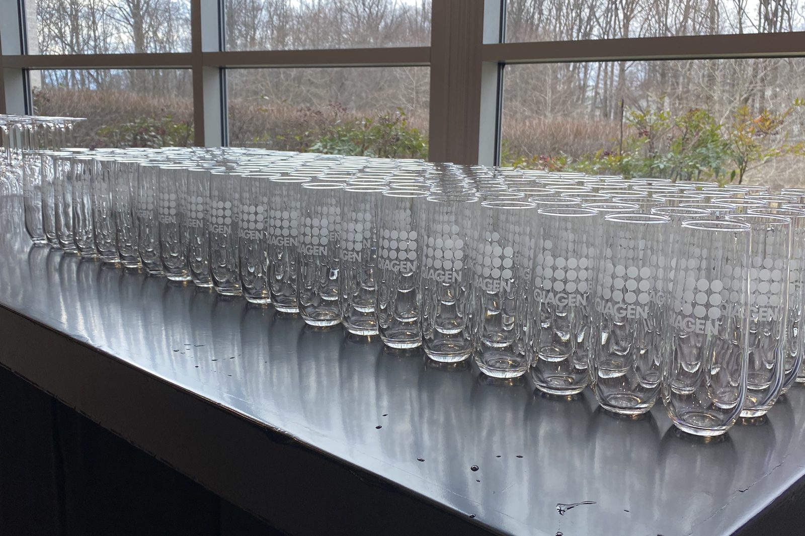 Rows of champagne flutes prepared at an event bar staffed by B Hospitality Group