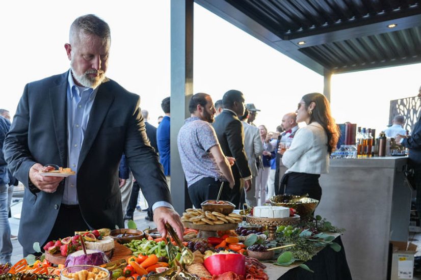 Guest serving himself from a grazing table at a rooftop corporate reception catered by B Hospitality Group in Washington, DC